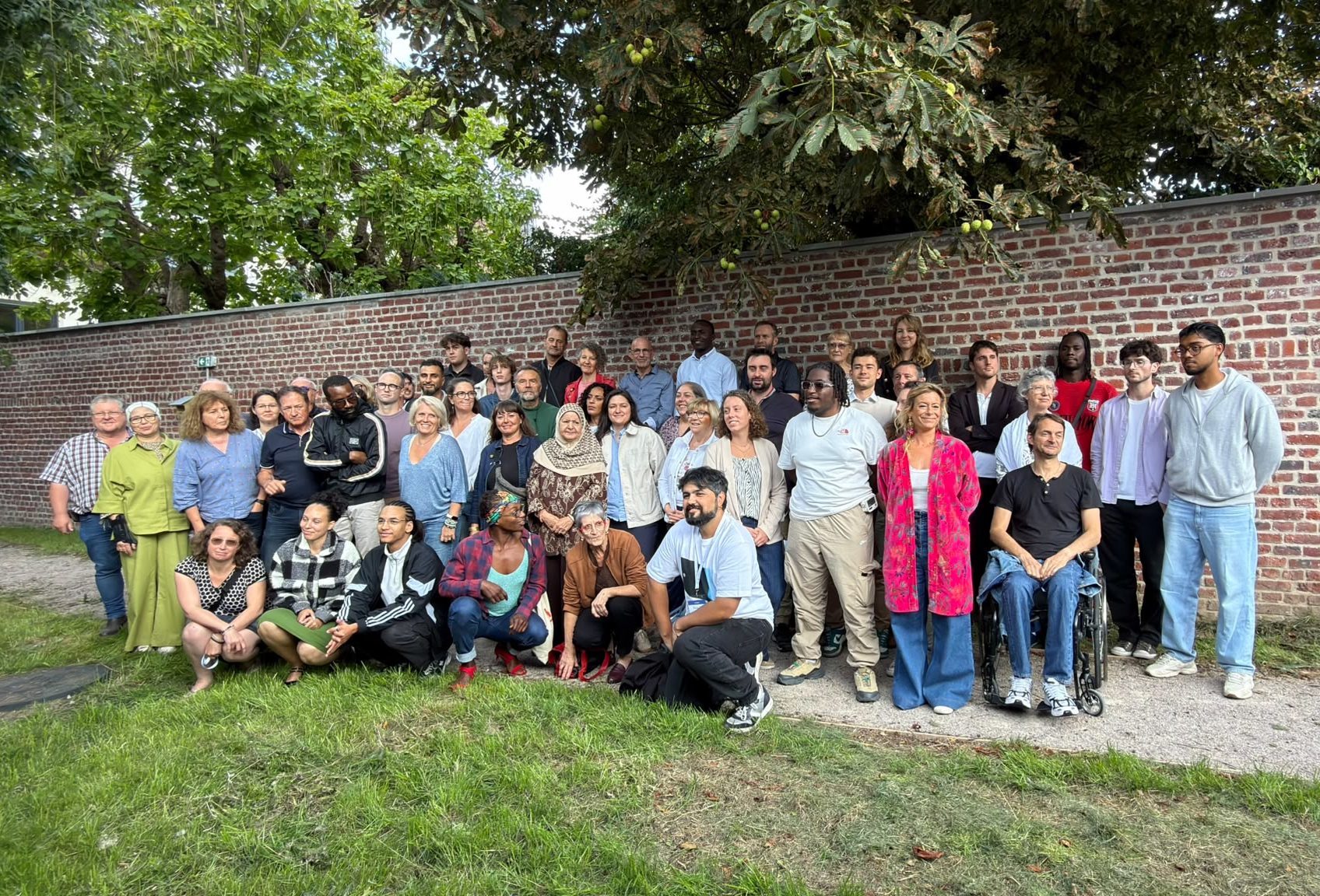 Photo de groupe des membres de la Convention, en plein air devant un mur de briques